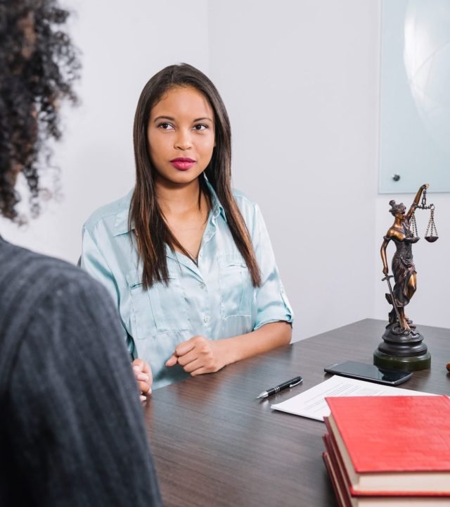 african-american-women-sitting-table-near-document-pen-figure-gavel (1)